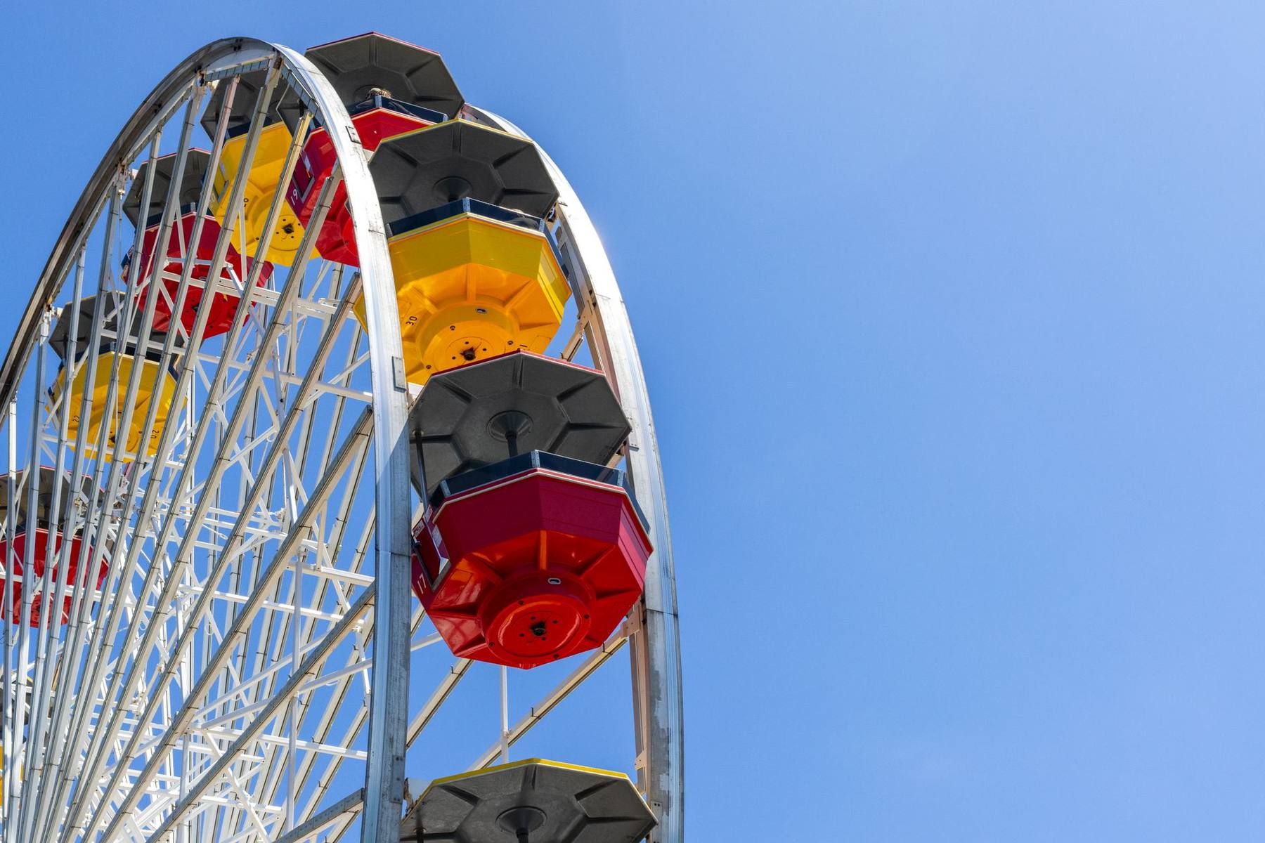 Ferris wheel and fairground rides under a bright sky